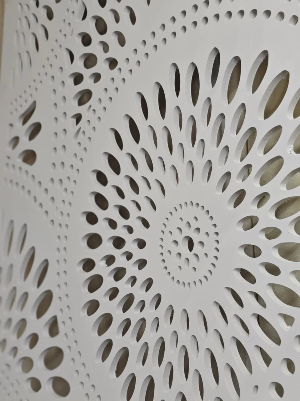 CNC-cut white WPC panel with mandala-style circular perforated jali design